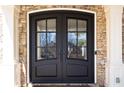 Elegant front door with glass panels, stone surround, and white pillars at 5303 Whitehaven Park Se Ln, Smyrna, GA 30126