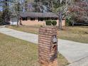 Classic brick exterior with a long driveway leading to the garage at 3685 Emily Way, Atlanta, GA 30349