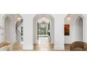 Elegant foyer with arched doorways, a spiral staircase, and a view of the front fountain at 5245 Kenbrook Way, Sandy Springs, GA 30327