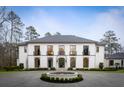 Charming two-story home with a circular driveway and fountain, beautifully landscaped at 5245 Kenbrook Way, Sandy Springs, GA 30327