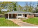 Charming brick home featuring a cozy front porch, carport, and a well-maintained lawn at 2792 Toney Dr, Decatur, GA 30032
