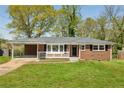Charming brick home featuring a cozy front porch, carport, and a well-maintained lawn at 2792 Toney Dr, Decatur, GA 30032