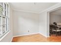 Bright, empty room features hardwood floors, white trim, and natural light streaming through a large window at 6700 Roswell Rd # 14C, Atlanta, GA 30328