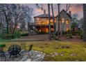 Expansive backyard featuring an outdoor fireplace, lush greenery, and a large deck perfect for entertaining at 275 Tynebrae Pl, Roswell, GA 30075