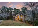 Charming two-story home featuring arched windows, mature trees, two-car garage, and landscaping at 275 Tynebrae Pl, Roswell, GA 30075
