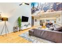 Cozy living area with hardwood floors, large mural, modern TV, and a comfortable leather sofa at 920 Memorial Se Dr # 35, Atlanta, GA 30316