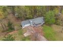 Aerial view of home showcasing mature trees and a long driveway to the house at 1074 Whooping Creek Rd, Carrollton, GA 30116