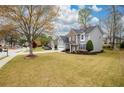 Spacious front lawn with view of two-story home featuring gray siding and brick accents at 4015 Embassy Way, Lilburn, GA 30047