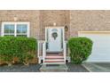 Close-up of front door of a brick home with white trim, bushes, and a wreath at 2160 Liberty Hts, Fairburn, GA 30213