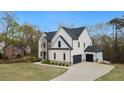 Stunning new home boasts a three-car garage, well-manicured lawn, and white painted brick exterior at 4980 Wildeoak Trl, Douglasville, GA 30135