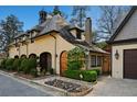 Charming exterior view showcasing the home's unique architecture and landscaped front yard at 23 Paces West Dr, Atlanta, GA 30327