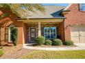 Inviting brick home with a stone-accented porch featuring a quaint seating area and pleasant curb appeal at 4540 Brighton View Trl, Cumming, GA 30040
