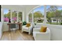 Bright sun room with large windows, hardwood floors, and cozy seating, ideal for a home office or reading nook at 102 Rockyford Ne Rd, Atlanta, GA 30317