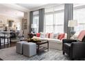 Bright living room featuring large windows, stylish decor, and a view into the dining area at 2500 Peachtree Nw Rd # 207S, Atlanta, GA 30305