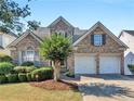 Attractive two-story home featuring a brick facade, manicured lawn and a convenient two-car garage at 152 Vinings Lake Ct, Mableton, GA 30126
