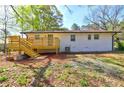 Backyard view of a brick home, featuring a wooden deck, stairs, and green space at 2248 Doris Dr, Decatur, GA 30034