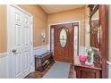 Inviting foyer featuring wood flooring, bench and stained front door with sidelights at 409 Hunting Ridge Way, Ellenwood, GA 30294