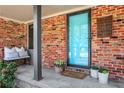 Inviting front porch with brick facade, a bench, and colorful potted plants at 2306 Ashleywoods Dr, Tucker, GA 30084
