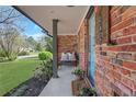 Charming brick front porch with seating, a welcome mat, and colorful plants at 2306 Ashleywoods Dr, Tucker, GA 30084