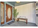 Inviting front porch featuring a stained wood door, a charming bench, and stylish decor at 2650 Ridge Valley Nw Rd, Atlanta, GA 30327