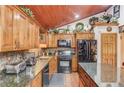 Charming kitchen featuring granite countertops, wood cabinetry, and modern appliances at 5494 Princeton Oaks Ln, Sugar Hill, GA 30518