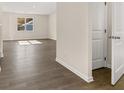Bright living room with wood-look flooring and large window providing natural light at 8229 Coldstream Dr, Fairburn, GA 30213