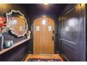 Welcoming entryway with a wooden front door, dark walls, decorative mirror, and hardwood floors at 103 Dartmouth Ave, Avondale Estates, GA 30002