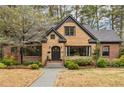 Charming home featuring a unique stone facade, a well-manicured lawn, and mature trees providing ample shade at 103 Dartmouth Ave, Avondale Estates, GA 30002