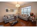 Cozy living room with hardwood floors, stylish sofas, and large windows offering natural light at 5143 Olive Branch Cir, Powder Springs, GA 30127