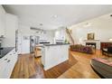 Open kitchen and living room featuring white cabinetry, stainless steel appliances and hardwood floors at 5300 Cottage Farm Rd, Johns Creek, GA 30022