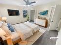 Virtually staged bedroom featuring a large window, closet, and a modern dresser at 724 Dukehart Ct, Stone Mountain, GA 30083