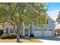 Attractive home featuring a well-maintained lawn, mature trees, and a two-car garage, radiating a welcoming atmosphere at 2445 Ridgelake Dr, Villa Rica, GA 30180
