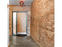 Hallway featuring brick walls, a door, and an 'EXIT' sign above the doorway at 490 Marietta Nw St # 105, Atlanta, GA 30313