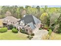 Aerial view of a stately home with a three-car garage and a well-maintained green lawn at 500 Poplar Creek Xing, Canton, GA 30114