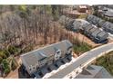 Aerial view of townhomes nestled in a community surrounded by trees and a road, offering a serene setting at 234 Retreat Ln, Canton, GA 30114