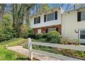 Welcoming townhouse with white picket fence, brick, and white siding on a sunny day at 382 Leisure Sw Ct, Marietta, GA 30064