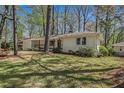 Well-maintained ranch with white painted brick, manicured lawn, and mature trees at 1863 Bruce Ne Rd, Atlanta, GA 30329