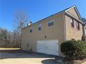 Side exterior showing a large, attached two car garage at 5761 Harrier Ln, Atlanta, GA 30349
