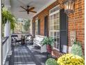 Charming front porch with brick facade, seating, plants, and pendant lighting at 121 Rising Star Rd, Fayetteville, GA 30215