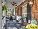Comfortable front porch with seating area, ceiling fan, and decorative plants and flowers at 121 Rising Star Rd, Fayetteville, GA 30215