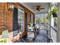 Cozy front porch with wicker chairs, ceiling fan, and decorative plants and ferns at 121 Rising Star Rd, Fayetteville, GA 30215