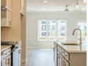 Bright kitchen showcases stainless appliances, gray cabinets, island sink and a large window at 1991 Deco Dr, Kennesaw, GA 30144