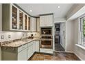 Corner kitchen featuring granite countertops, stainless appliances, and glass cabinets at 205 Glencourtney Dr, Sandy Springs, GA 30328
