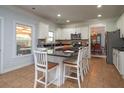 Bright kitchen featuring white cabinetry, granite countertops, an island with barstool seating, and modern appliances at 1871 Shiloh Valley Nw Way, Kennesaw, GA 30144