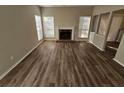 Spacious living room with modern hardwood flooring, a cozy fireplace, and great natural lighting at 6406 Laurel Post Dr, Lithonia, GA 30058