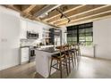 Modern kitchen with stainless steel appliances, marble backsplash, an island with bar seating, and exposed pipes at 1065 United Ave # 208, Atlanta, GA 30316