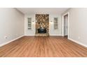 Living room features a floor to ceiling stone fireplace, wood floors, neutral paint, and natural light at 2938 Parkwood Rd, Snellville, GA 30039