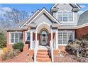 Close-up of the front porch featuring brick steps, white railings, and a glass front door at 1092 Shumard Ln, Mcdonough, GA 30252