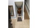 Hallway with neutral tile floors, access to stairs, and a view into the kitchen at 2469 Briar Knoll Rd, Lithonia, GA 30058