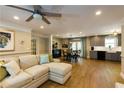 Spacious living room with hardwood floors, a comfortable sectional sofa, and an open view to the dining area and kitchen at 5369 Blue Grass Ln, Sugar Hill, GA 30518